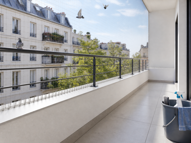 Balcon propre protégé par un filet et des pics anti-pigeons pour éviter leur retour après nettoyage