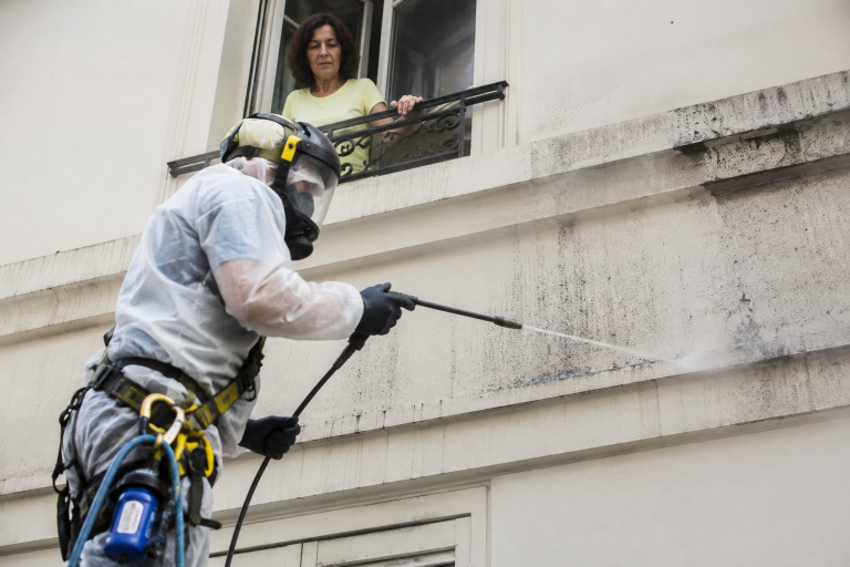 Professionnel protégeant les habitations voisines lors d’un nettoyage de fientes sur un balcon